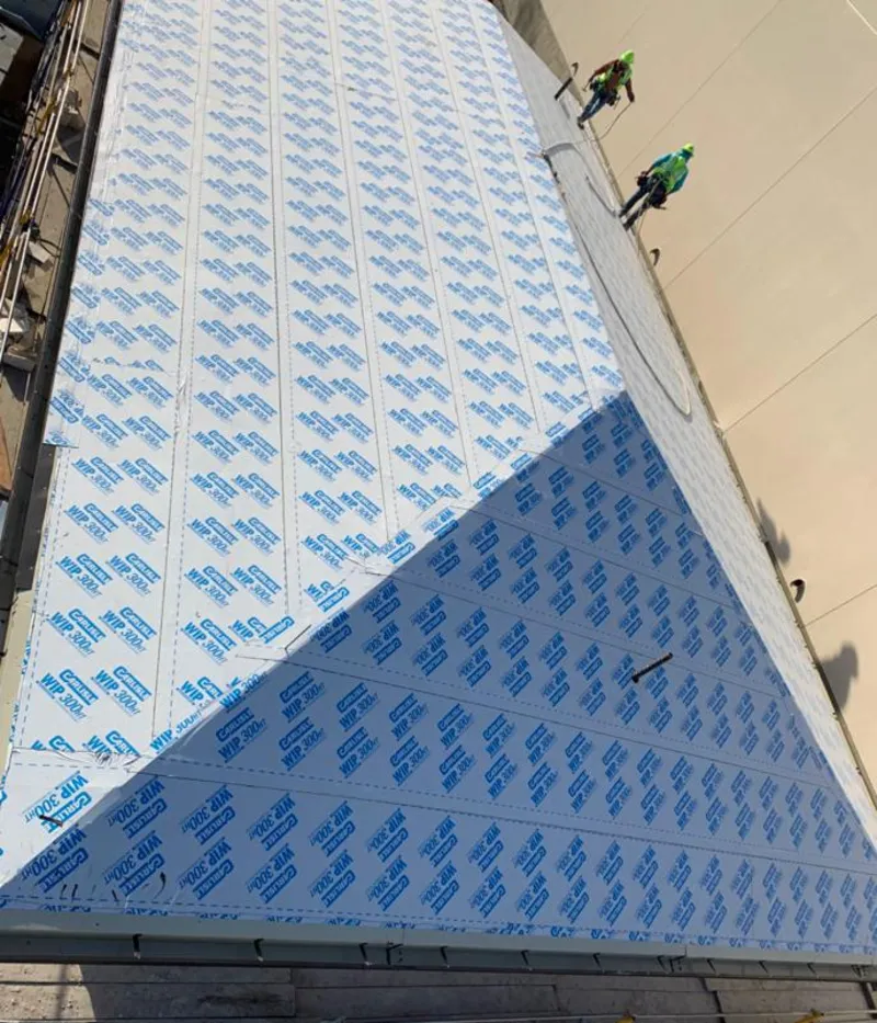 Professional roofers installing underlayment on a metal roof in Towamencin